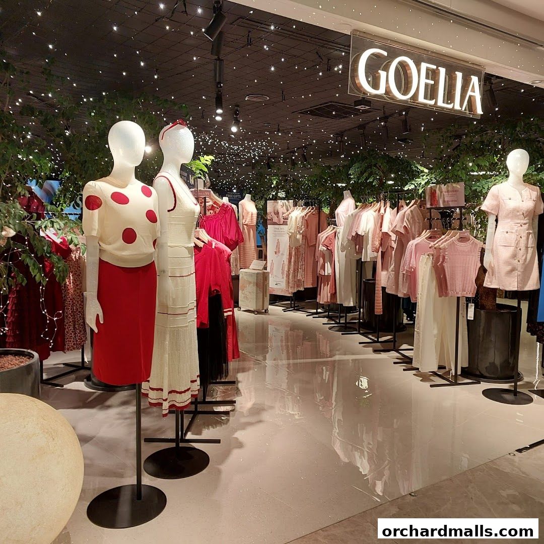 Mannequins display stylish women's clothing in a well-lit boutique with lush greenery.