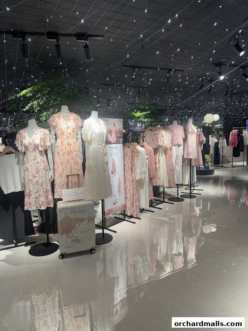 Mannequins display floral dresses and clothing in a well-lit retail store.