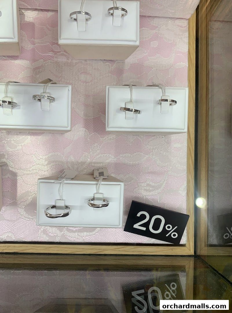 A display of elegant rings with a 20% off sign in a jewelry store.