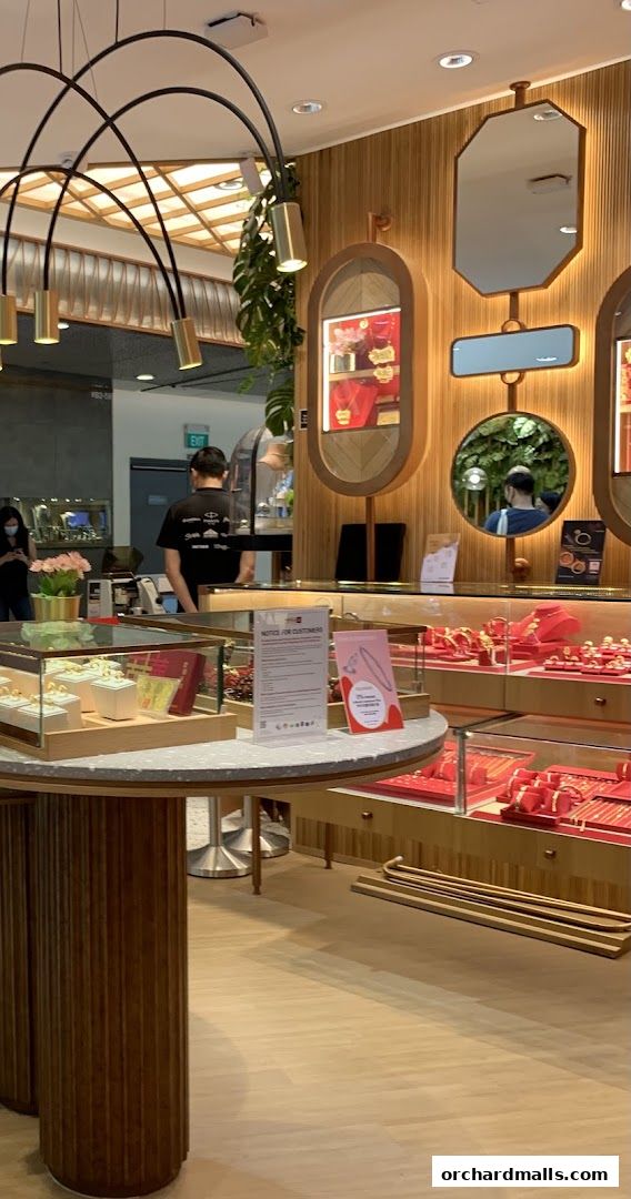 Interior of a jewelry store with display cases filled with gold jewelry and a notice for customers.