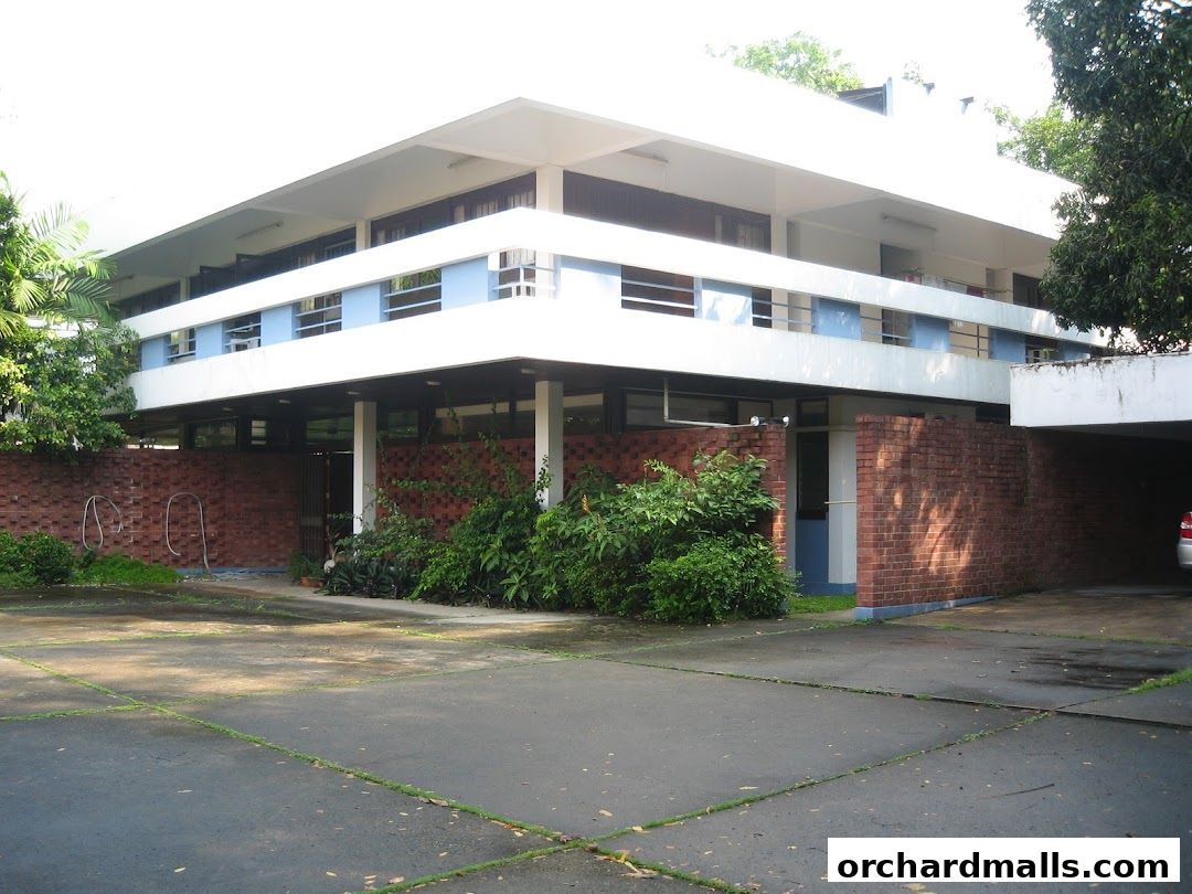 Exterior view of a modern building with brick accents and lush greenery.