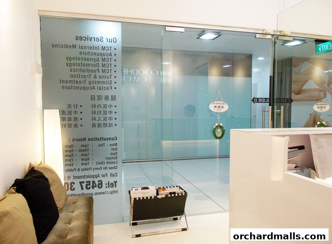Entrance of Goodhealth TCM Clinic with services listed on the glass door.