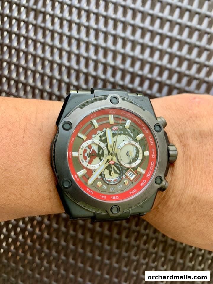 A close-up shot of a man's wrist wearing a black and red luxury chronograph watch.