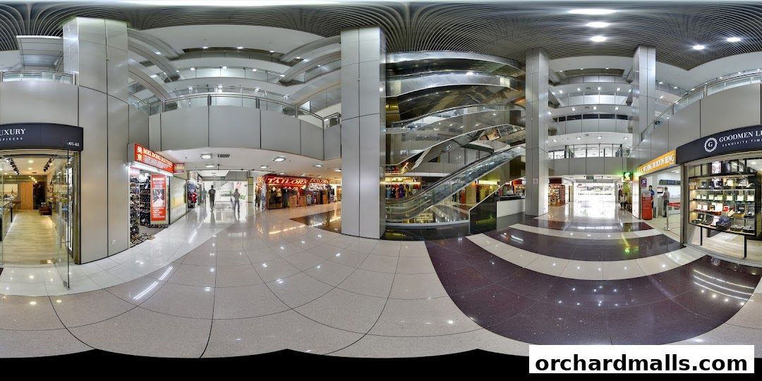 Interior view of a shopping mall with multiple shops, escalators, and walkways.
