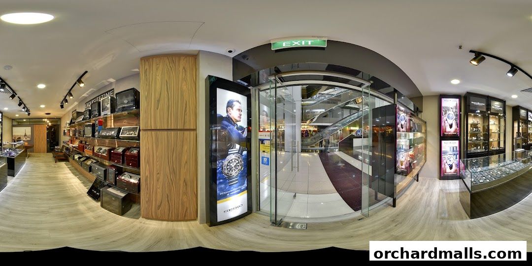 Interior view of a luxury watch store with display cases and promotional posters.