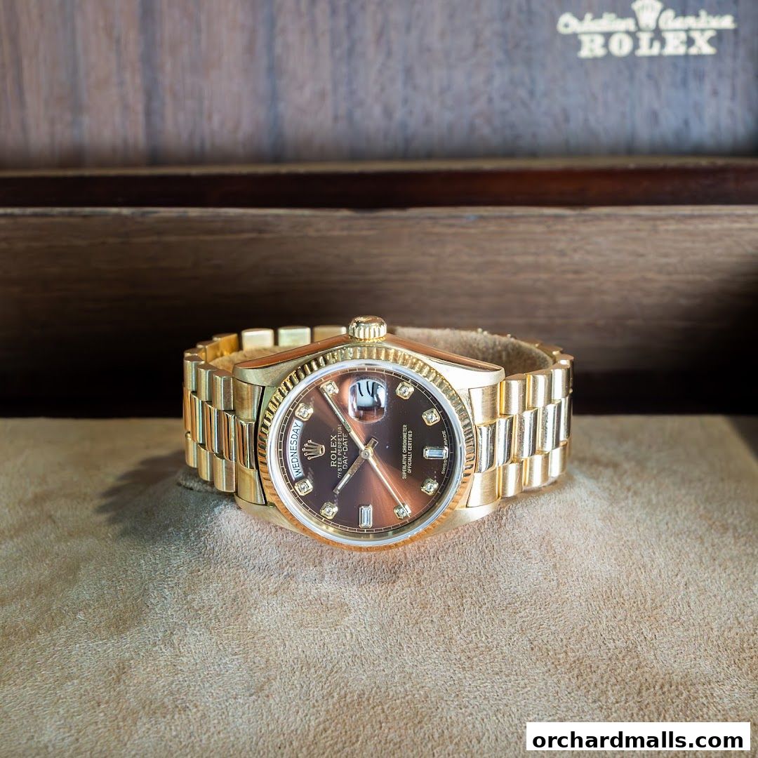 A luxurious gold Rolex watch with a brown dial and diamond markers.