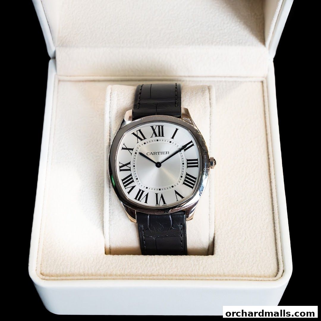 A luxurious Cartier watch with a black leather strap presented in its white box.