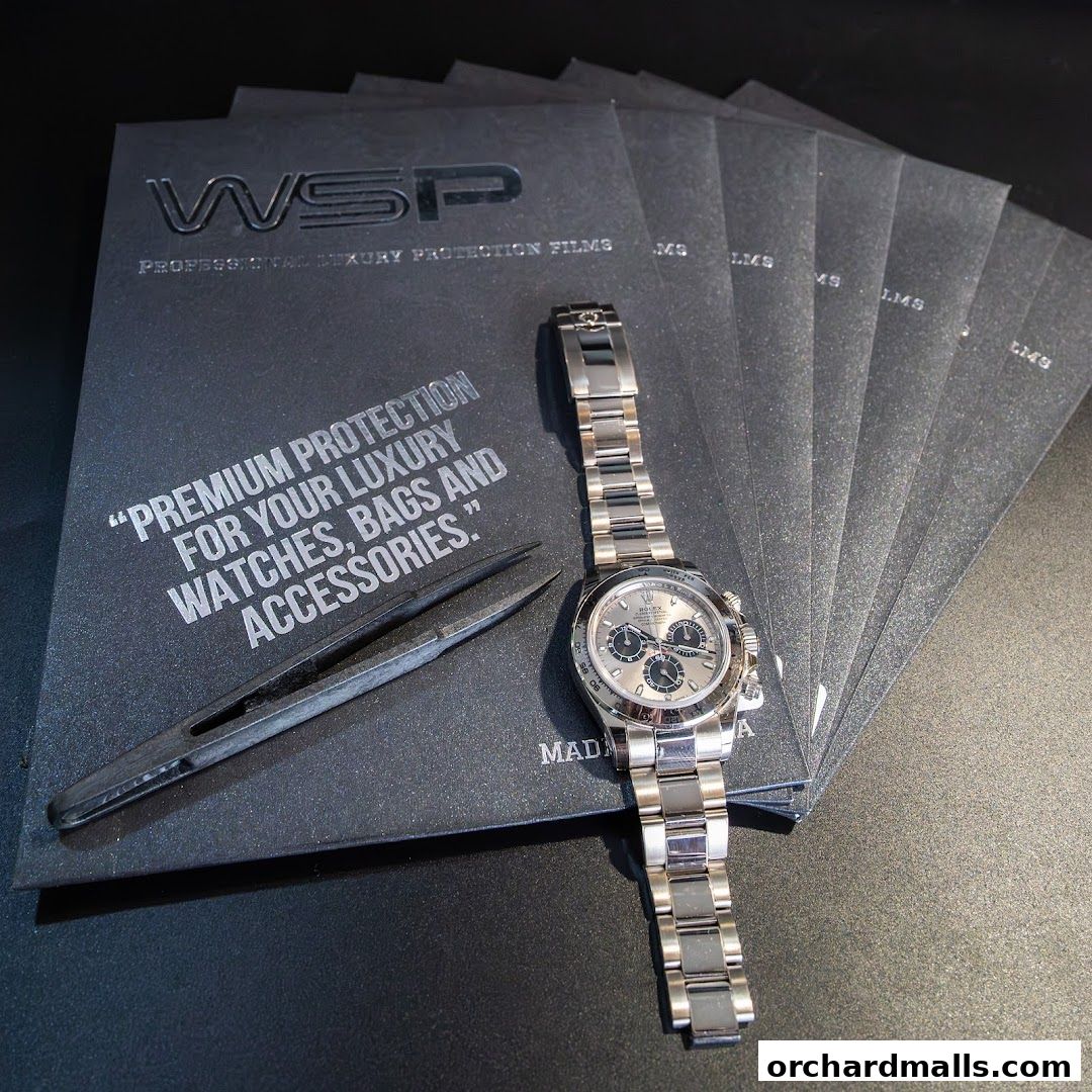A luxury watch and tweezers are displayed on protective film packaging.