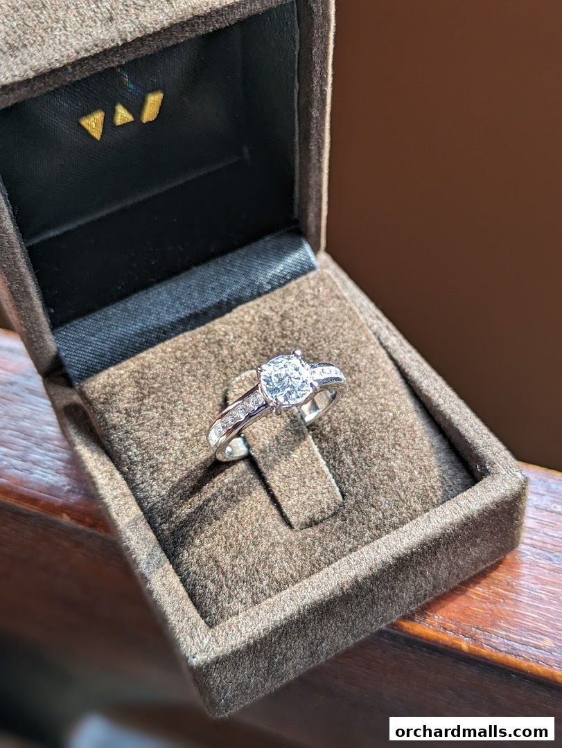 A diamond ring in a brown velvet jewelry box.