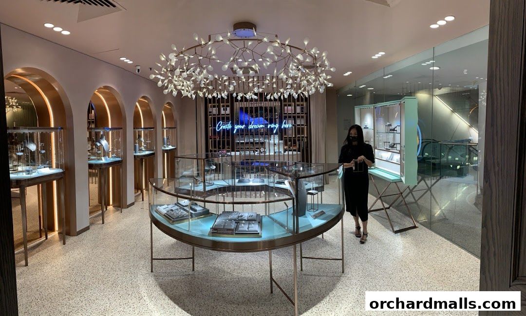Interior of a modern jewelry store with display cases and a chandelier.