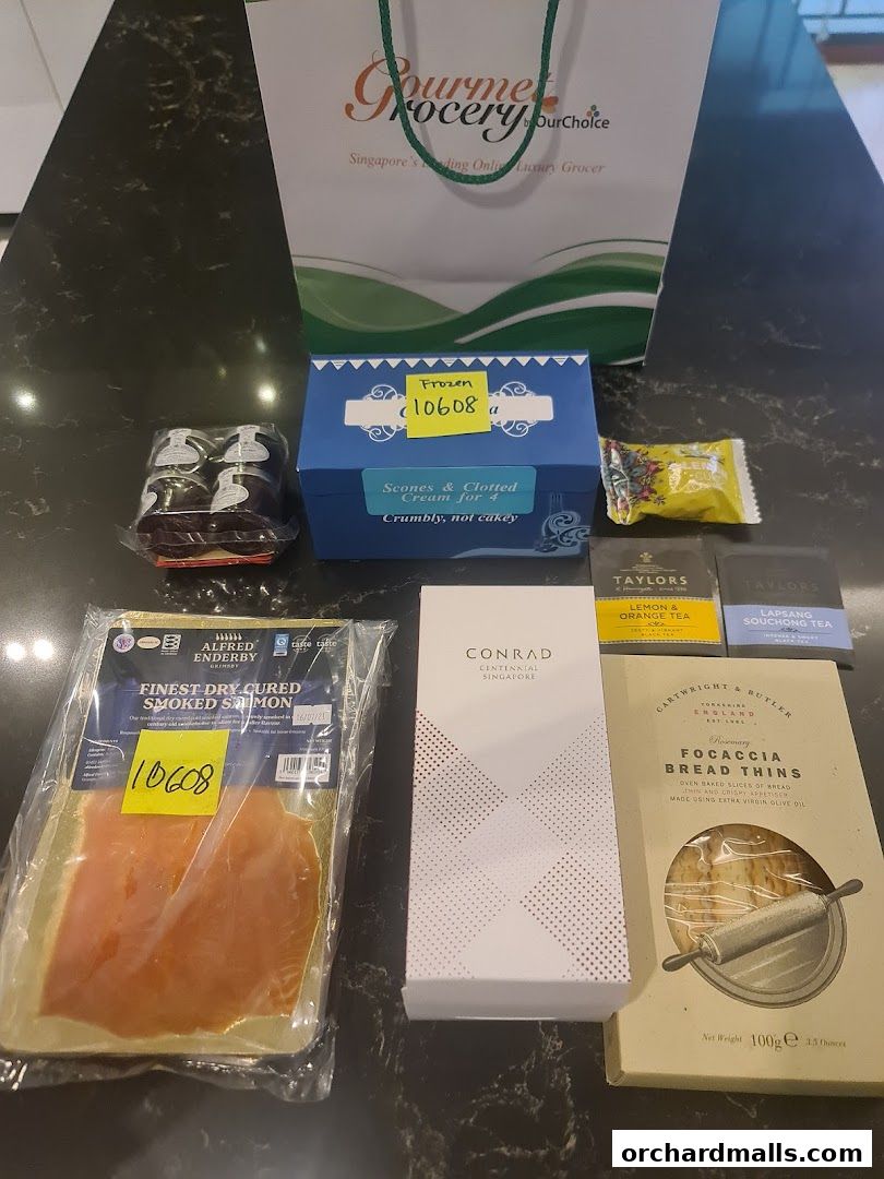 A collection of gourmet food items from Gourmet Grocery by OurChoice, including smoked salmon and tea.