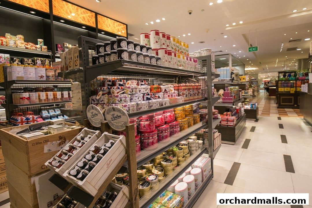 Interior view of a gourmet grocery store with shelves stocked with jams, teas, and other food items.
