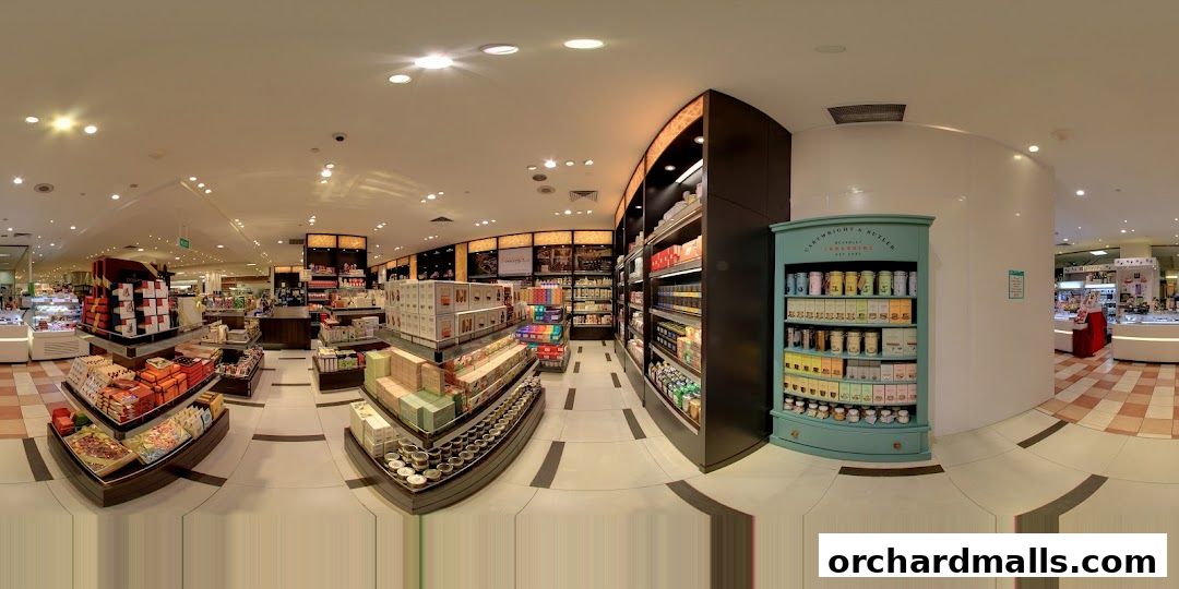 Interior view of a gourmet grocery store with shelves stocked with various food items and gifts.