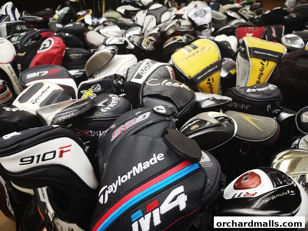 A large collection of various golf club headcovers and some golf clubs.