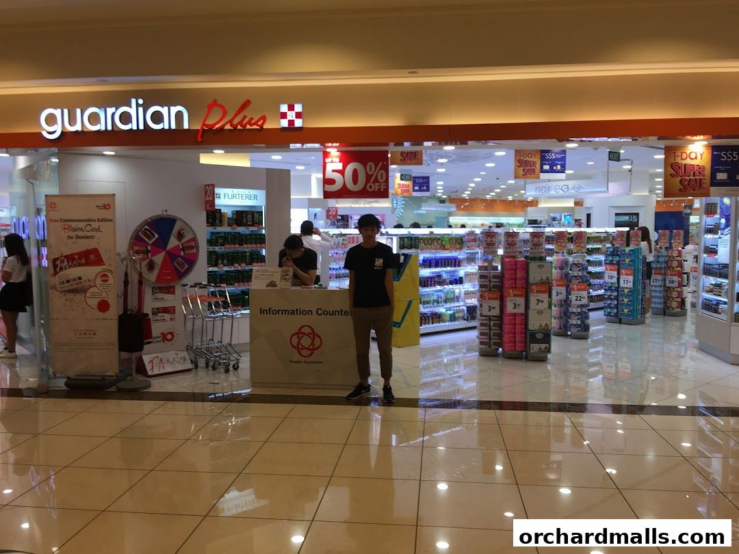 Guardian Plus store entrance with promotional displays and shelves stocked with health and beauty products.