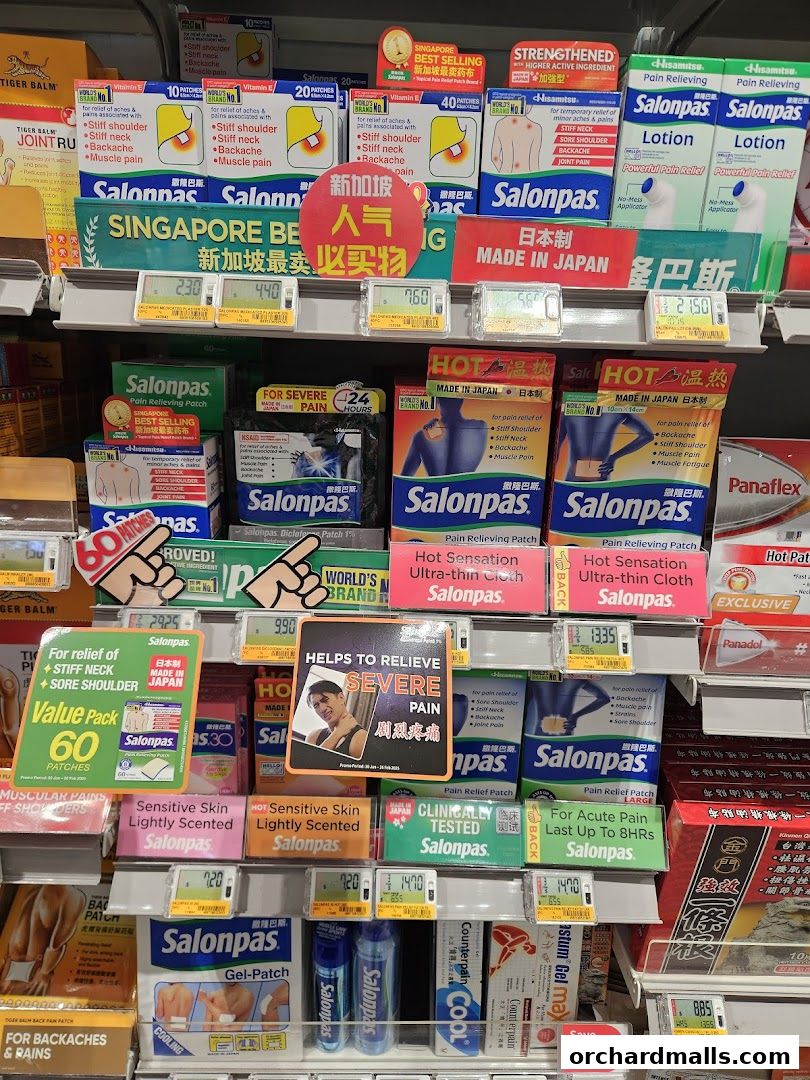 A retail display shelf filled with various pain relief patches and lotions from brands like Salonpas and Tiger Balm.