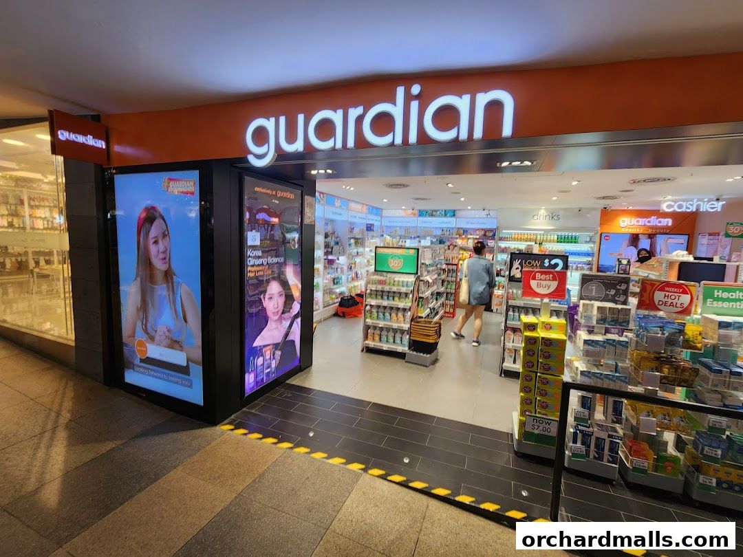 The entrance of a Guardian Health & Beauty store with illuminated signage and product displays.