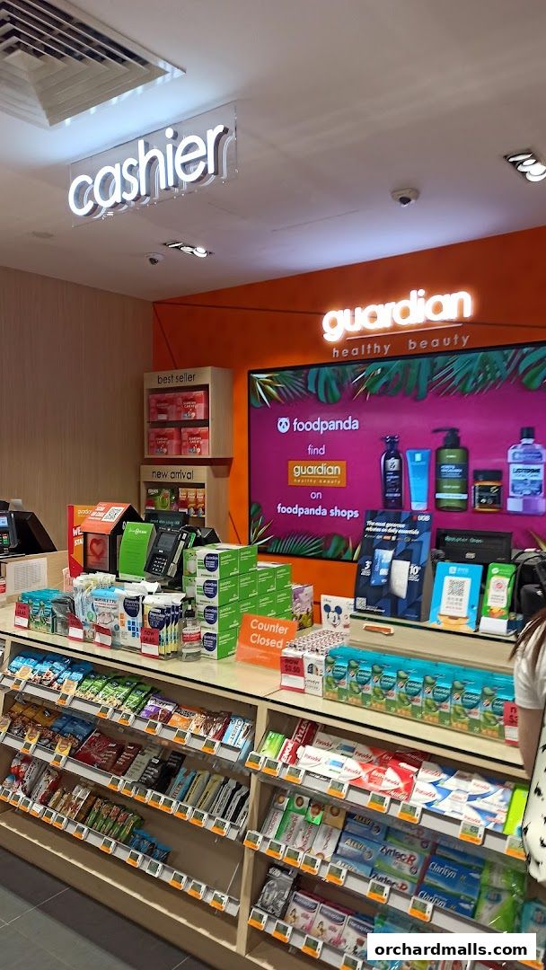 Interior view of a Guardian Health & Beauty store with shelves stocked with products and a cashier counter.