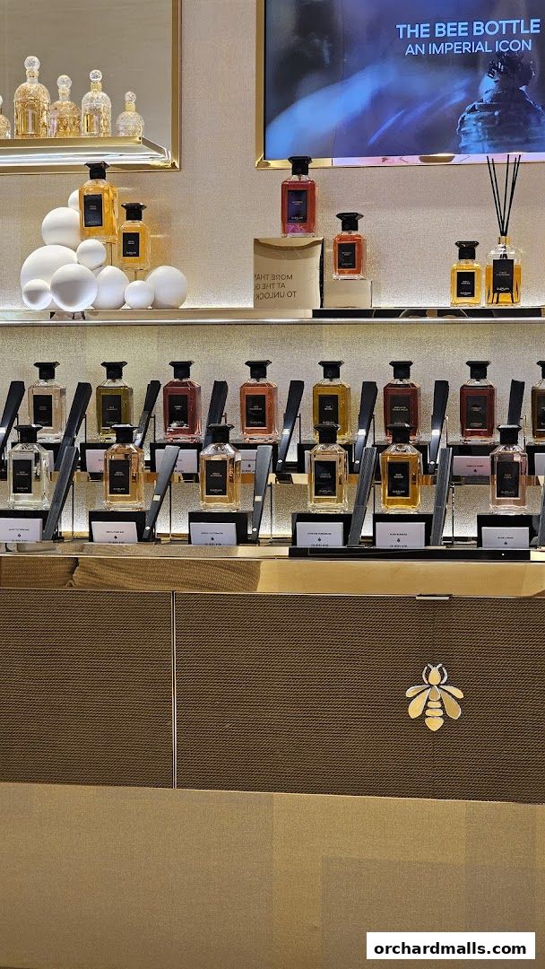 Guerlain boutique interior showcasing various perfumes on display shelves with a bee logo.