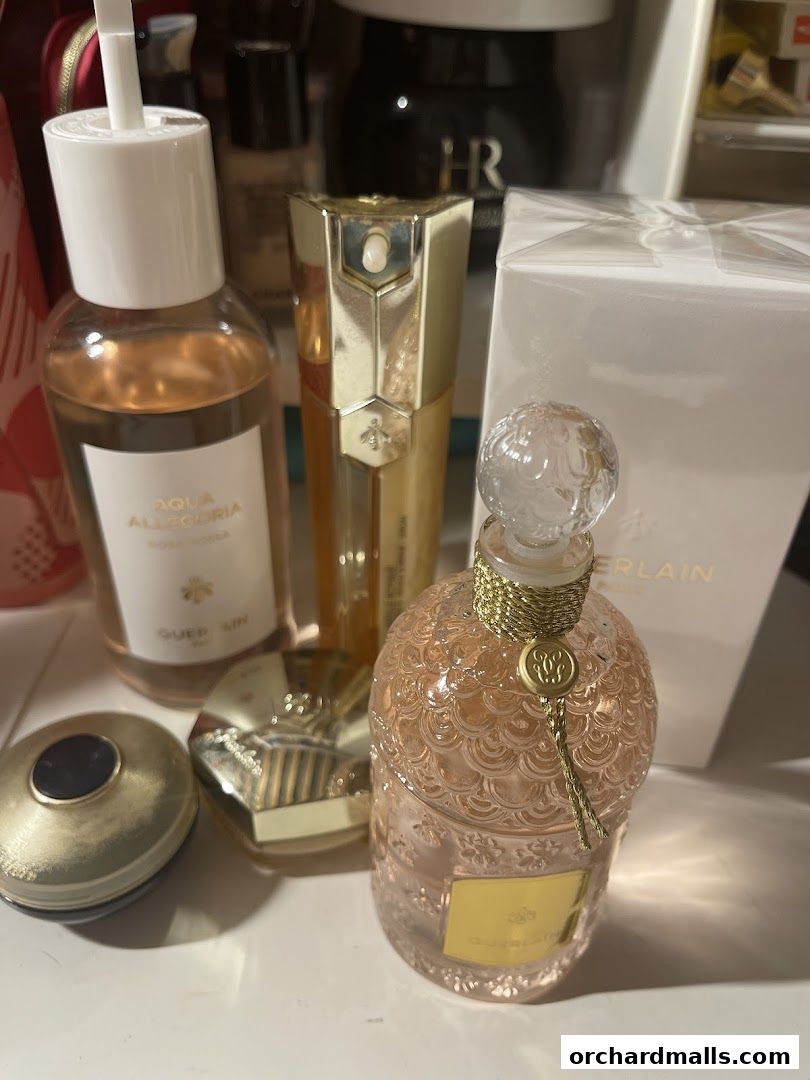 A collection of Guerlain perfumes and beauty products displayed on a surface.