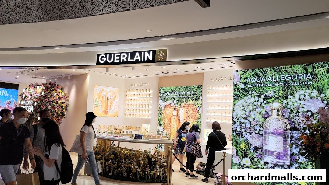 The Guerlain boutique entrance with displays of perfumes and floral arrangements.
