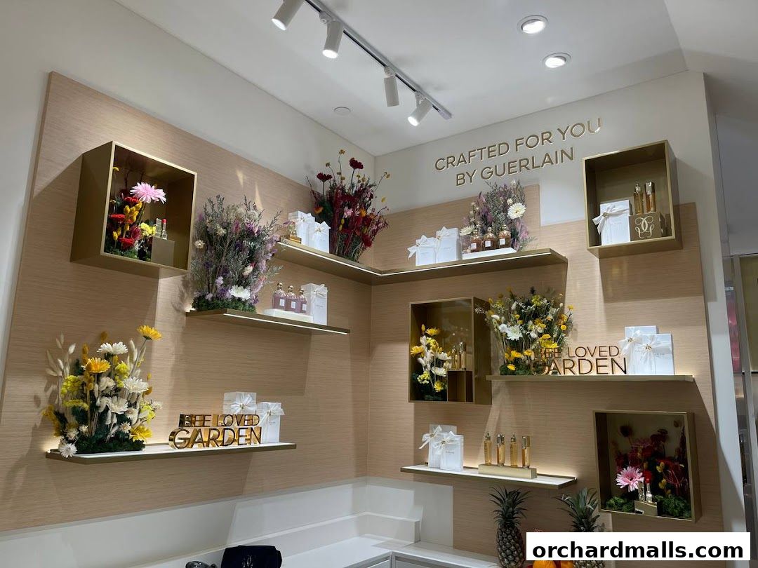 Guerlain boutique interior with shelves displaying perfumes, gift boxes, and floral arrangements.