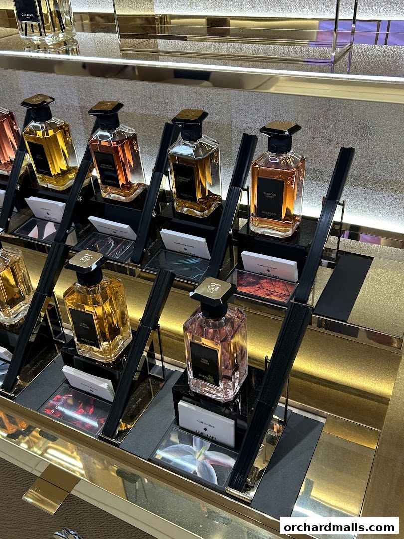 Guerlain perfumes displayed in elegant bottles on a golden shelf.