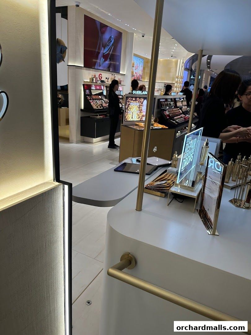 Interior of a Guerlain boutique showcasing makeup displays and customers.