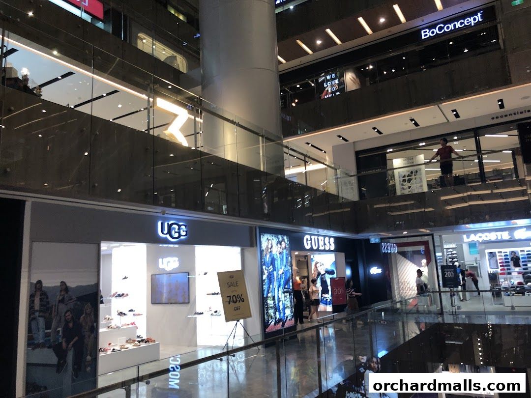 A view of the GUESS store and surrounding shops in a modern shopping mall.