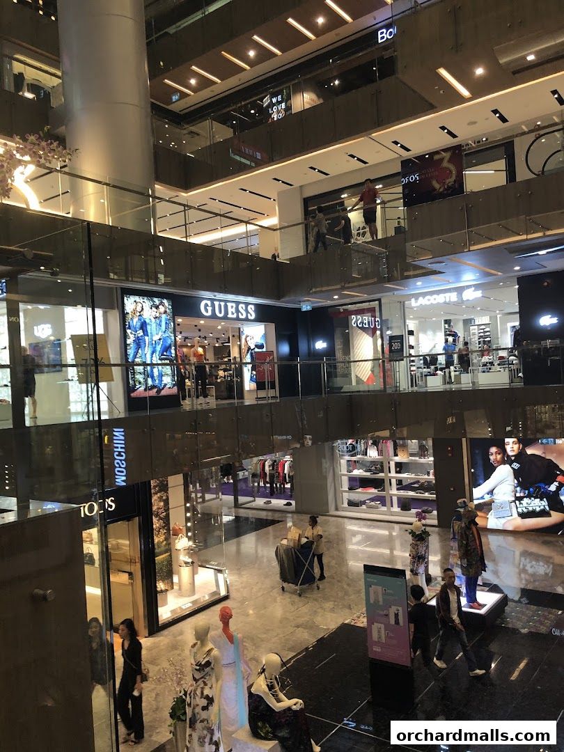 Interior view of a multi-level shopping mall with various retail stores visible.