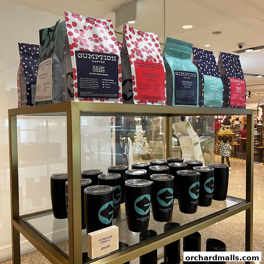 Display of Gumption Coffee bags and tumblers on shelves in a retail store.