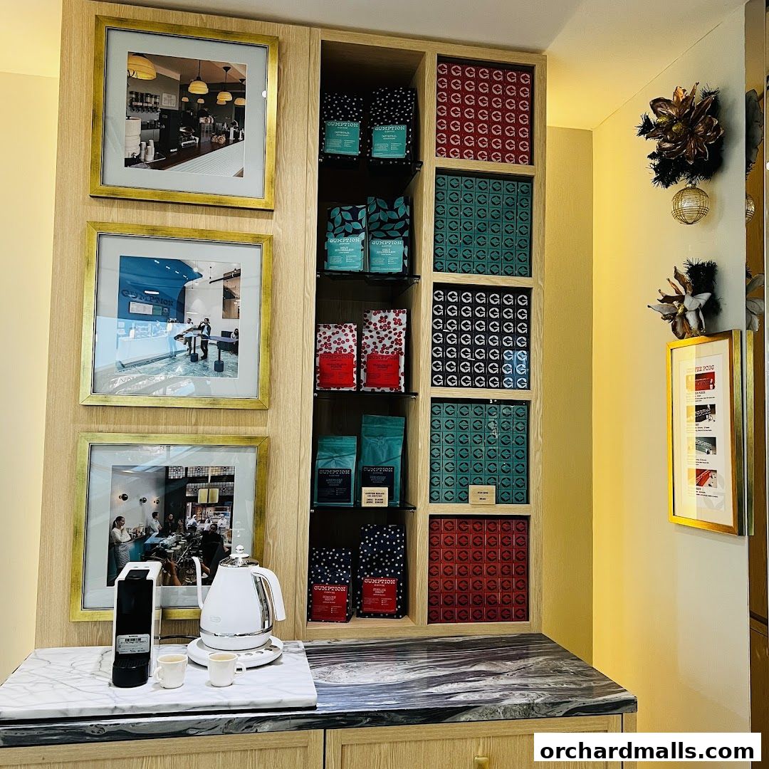Gumption Coffee shop display with coffee bags, framed photos, and brewing equipment.