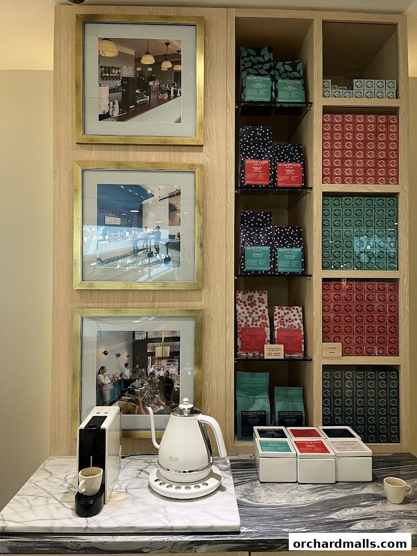 Gumption Coffee shop display with framed photos, coffee bags, and brewing equipment.