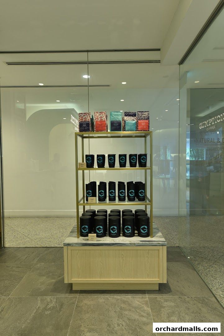 A display shelf with coffee bags, cups, and canisters from Gumption Coffee.
