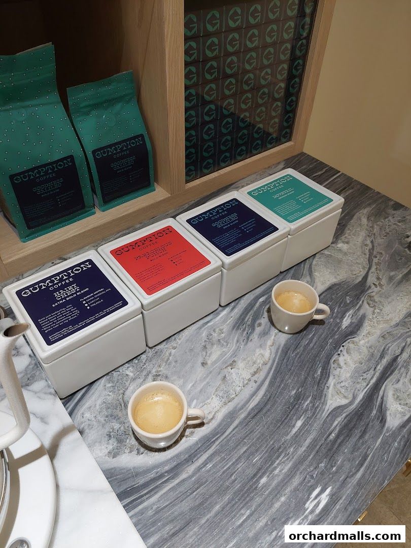 Gumption Coffee display featuring coffee bags, canisters, and cups of espresso.