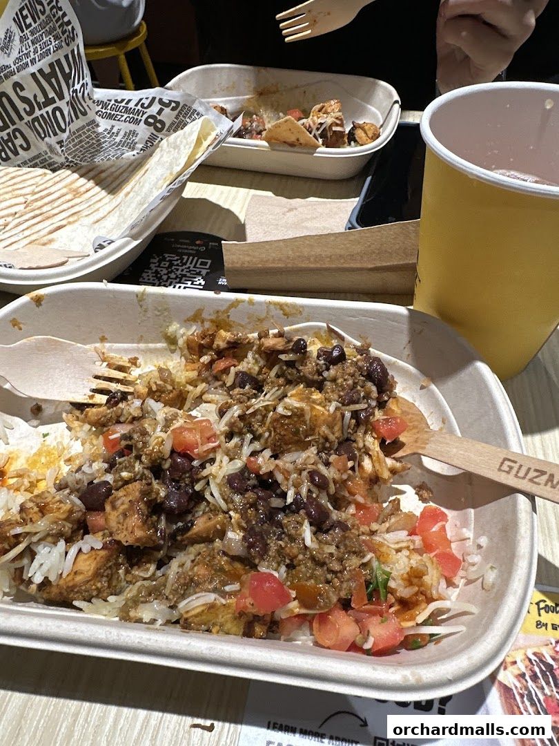 A close-up of a delicious Guzman y Gomez burrito bowl with rice, beans, chicken, and salsa.