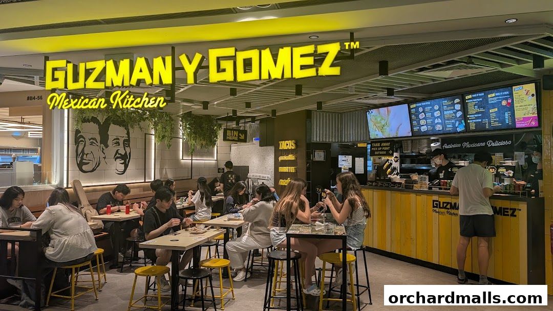Customers dine at Guzman y Gomez Mexican Kitchen, with a vibrant counter and menu displayed.