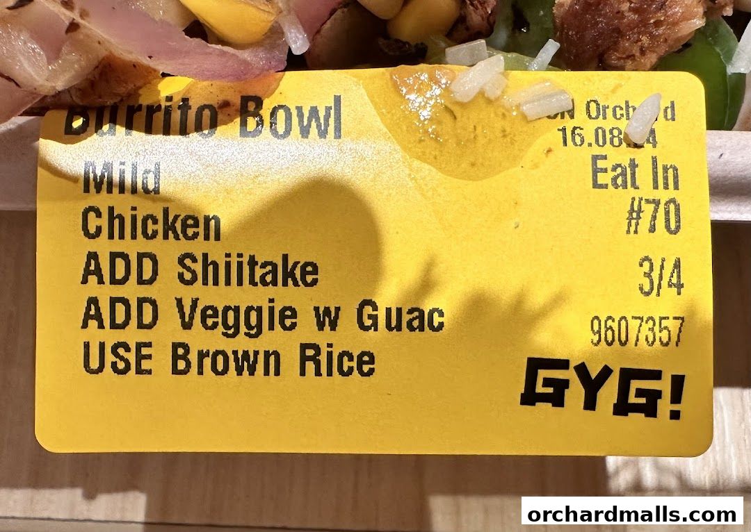 A close-up of a Guzman y Gomez order ticket showing a burrito bowl with chicken and additions.