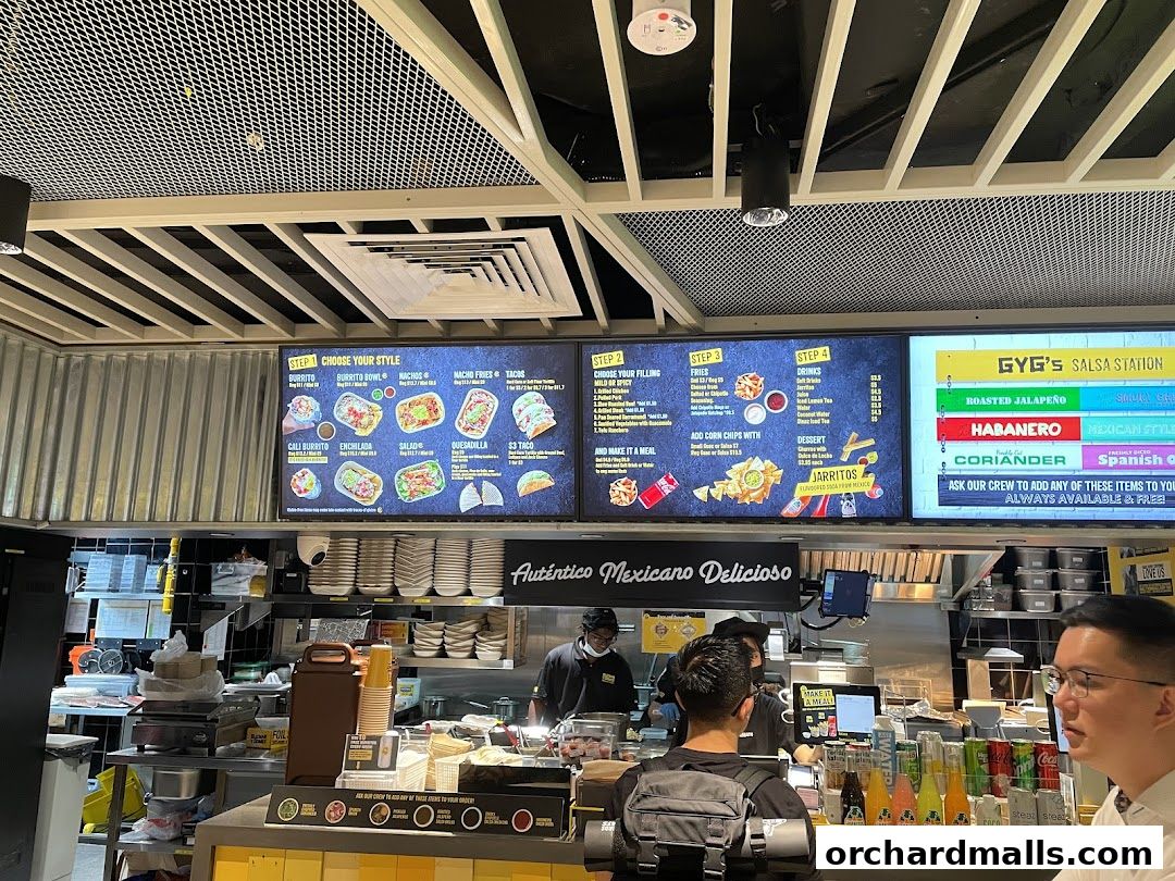 A digital menu board displays food and drink options at Guzman y Gomez.
