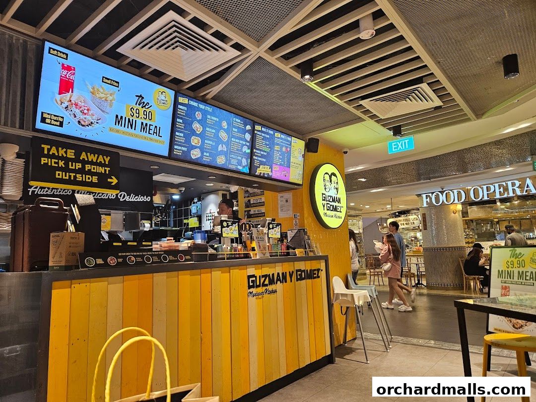 Guzman y Gomez restaurant counter with digital menus displaying food and prices.