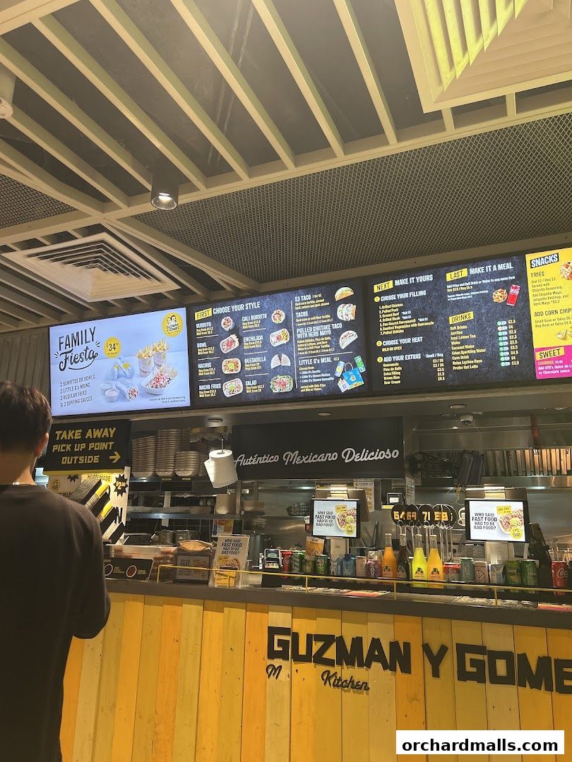 A Guzman y Gomez restaurant counter with a digital menu displaying food and drink options.