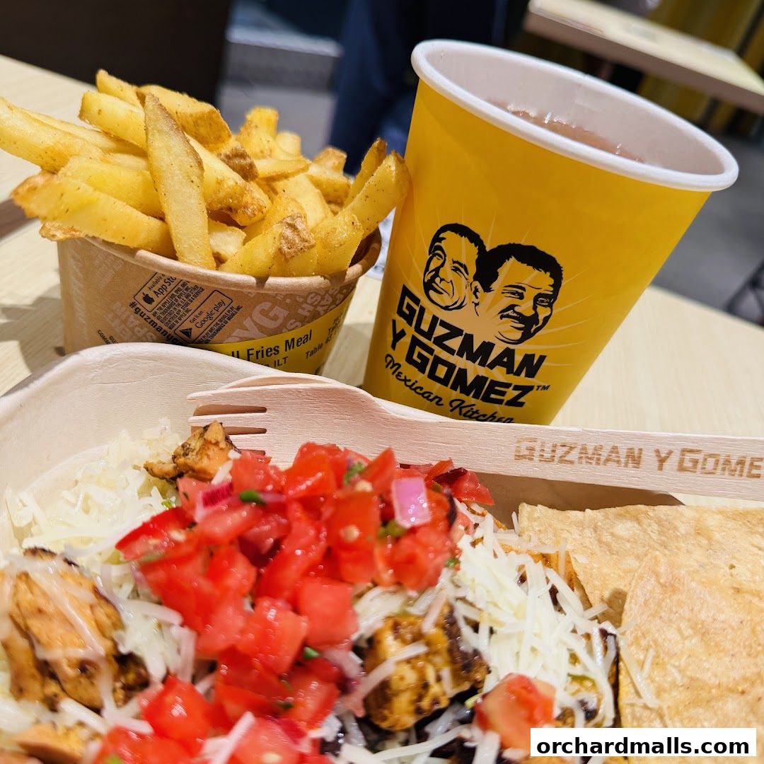 A close-up of a Mexican meal with chicken, rice, salsa, cheese, fries, and a drink.