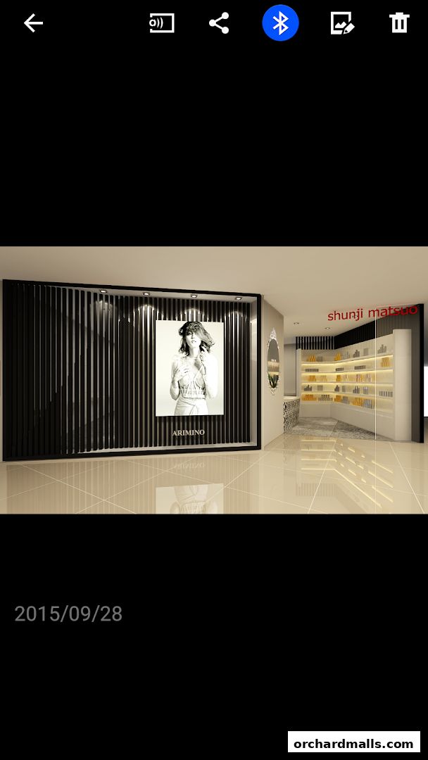 Interior view of a modern hair salon with product displays and a large advertising poster.