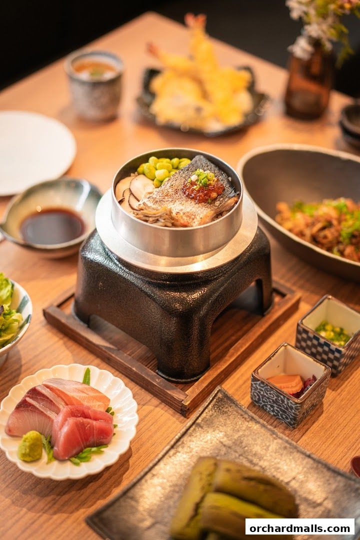 A table setting with various Japanese dishes, including sashimi, rice, and tempura.