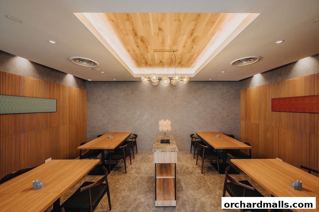 Interior of a modern restaurant with wooden tables and chairs, and elegant lighting.