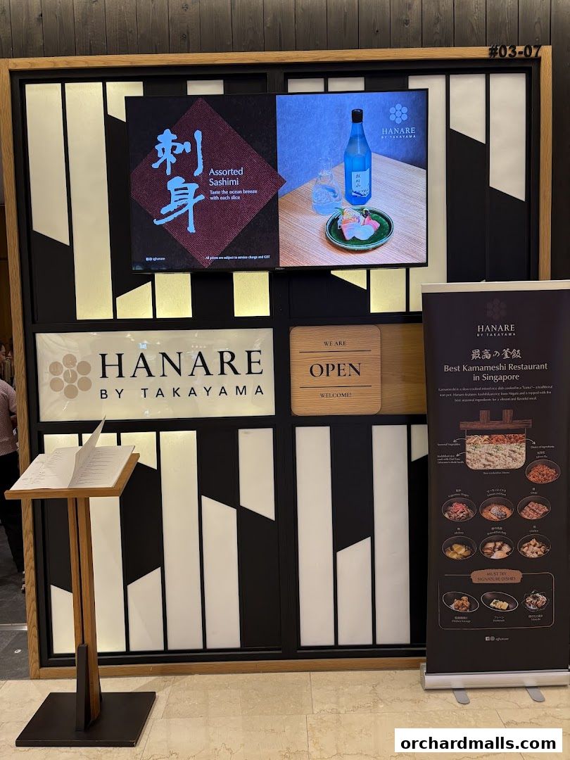 The entrance of Hanare by Takayama, a Japanese restaurant, with signage and a display of their offerings.