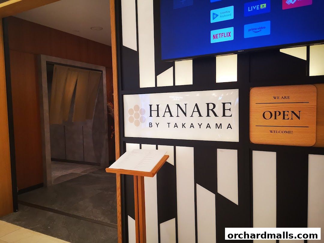 The entrance to Hanare by Takayama, featuring a menu stand and an open sign.