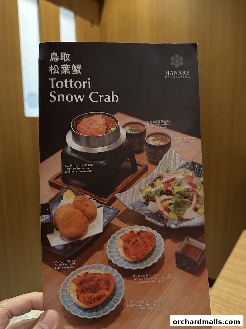 A menu showcasing Tottori Snow Crab dishes including kamameshi, croquettes, and gratins.