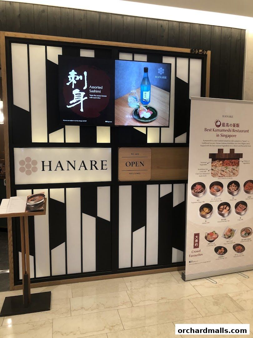 The exterior of Hanare, a Japanese restaurant, featuring its logo, menu displays, and a promotional banner.