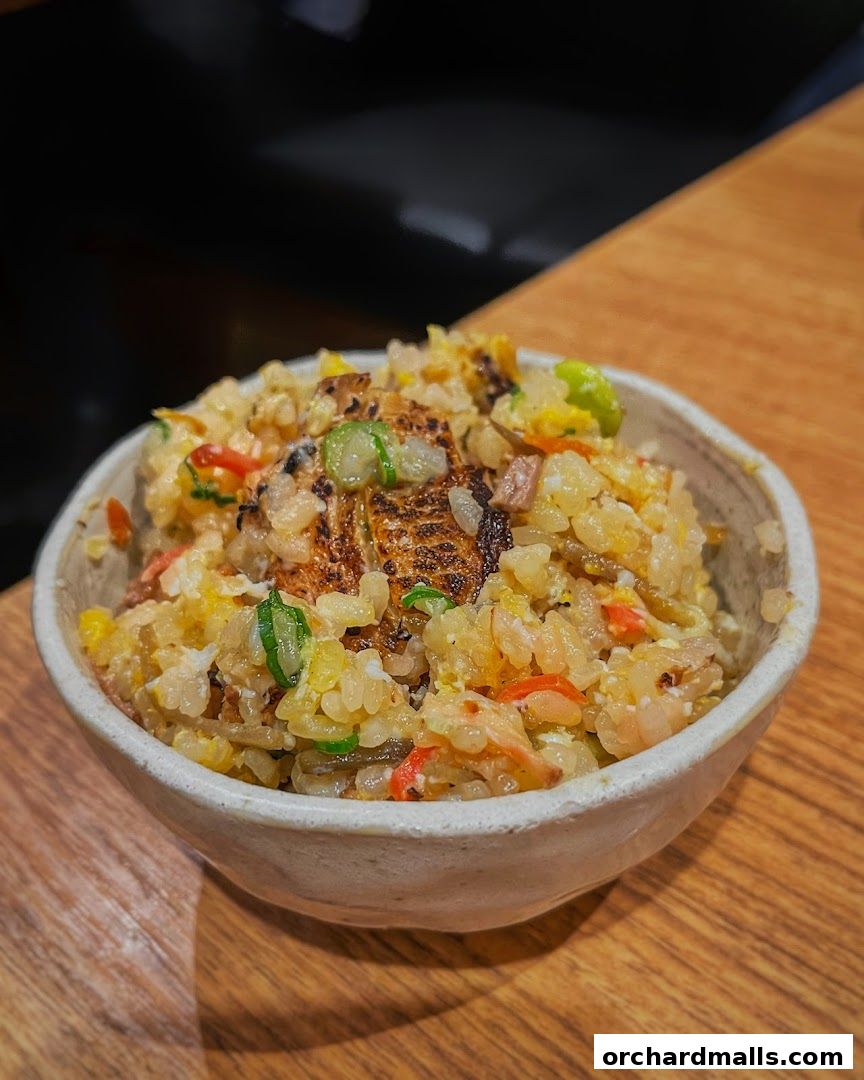 A close-up shot of a bowl of delicious fried rice with various ingredients.